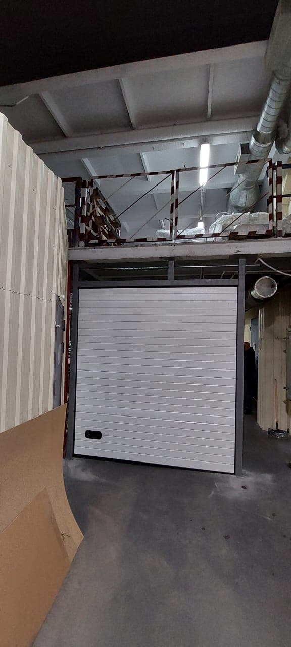 Установили подъемно-секционные ворота в производственном помещении на ул. Оптиков, 4.